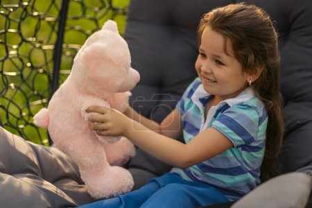 Photo for Girl playing with her teddy bear being in nature - Royalty Free Image