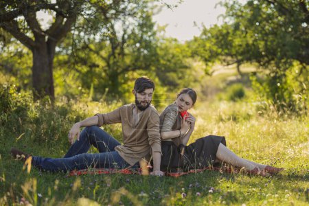 Téléchargez les photos : Jeune couple dans la nature, une fille avec un téléphone envoie un texto à quelqu'un - en image libre de droit