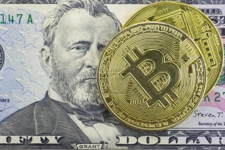 Photo for Bitcoin coins lie on a fifty dollar bill, close-up - Royalty Free Image