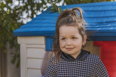 Photo for Portrait of a little girl playing outdoors near her house - Royalty Free Image