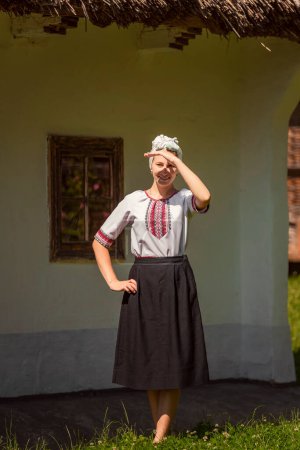 Photo for A woman in Ukrainian national costume walks on the lawn - Royalty Free Image