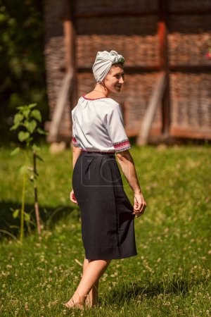 Photo for A woman in Ukrainian national costume walks on the lawn - Royalty Free Image