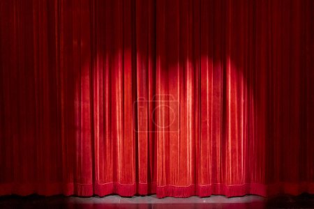 Foto de Cortinas rojas en un pequeño teatro, con un foco de atención a la anticipación del espectáculo. - Imagen libre de derechos