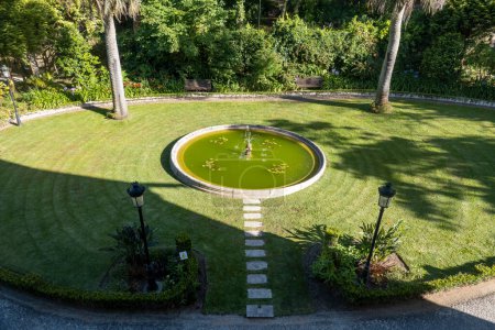 Téléchargez les photos : SINTRA, PORTUGAL - 27 JUIN 2022 : Belle vue sur le jardin avec une fontaine du monument Chalet Biester dans le village de Sintra. - en image libre de droit