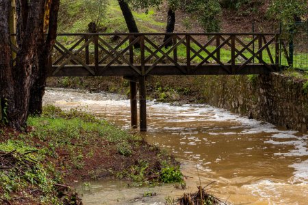 Foto de View of the Heavy rains creating high flow brown river water in Sao Bras de Alportel, Fonte Ferrea location, Portugal. - Imagen libre de derechos