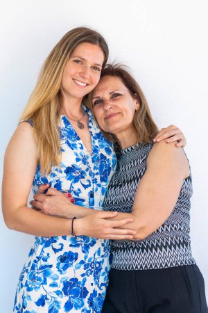 Daughter and mother together, smiling, on a white background.