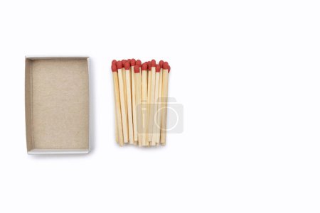 Matches near an empty cardboard matchbox isolated on a white background. Matches and empty open matchbox close-up with space for text. Matches with a red head