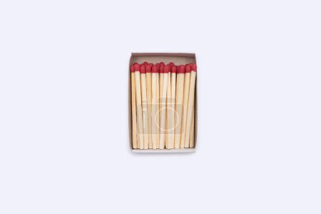 Matches in a matchbox. An open cardboard matchbox filled with matches on a white background. Top view of matches close-up with space for text.