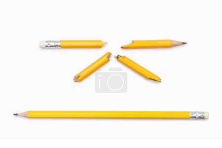 Gebrochener und ganzer Bleistift auf weißem horizontalen Hintergrund. Zwei gelbe Bleistifte aus Graphit, in viele Einzelteile zerbrochen und in Großaufnahme. Emotionen, Stress, Wut, Aggression, Probleme im Studium, bei der Arbeit.