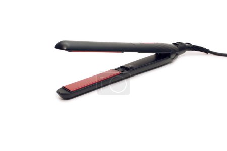 Black electronic hair straightener isolated on white background close-up. Hair straightener with ceramic plates for styling hair. The concept of styling hair at home