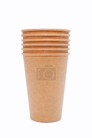 Téléchargez les photos : Une pile de tasses à café jetables sur un fond blanc. Il existe de nombreux gobelets en carton qui peuvent être recyclés à partir de papier kraft. Tasses en papier jetables. Concept sans déchets, sans plastique - en image libre de droit