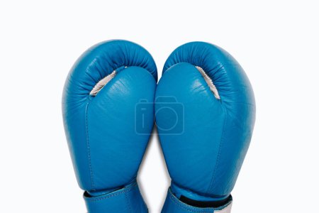 Ein Paar blaue Boxhandschuhe aus Leder in Großaufnahme von oben. Blaue Boxhandschuhe isoliert auf weißem Hintergrund. Boxzubehör