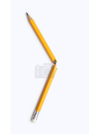 Zerbrochene Bleistift auf weißem Hintergrund Nahaufnahme auf vertikalem Hintergrund. Ein gelber Bleistift aus Graphit, in der Mitte gebrochen, als Manifestation von Emotionen, Stress, Aggression, Problemen im Studium oder bei der Arbeit.