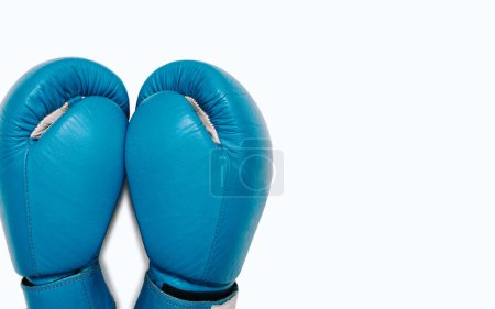 Blue boxing gloves isolated on white background with free space for text. A pair of blue leather boxing gloves close-up top view.