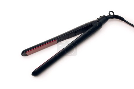 Black hair straightener isolated on white background. Electronic hair straightener with ceramic plates top view. Hair styling tool. The concept of hair care at home