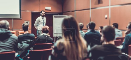 Photo for Public Speaker Giving a Talk at Business Meeting. Audience in the conference hall. Skilled coach answers questions of participants of business training. Business and Entrepreneurship concept. - Royalty Free Image
