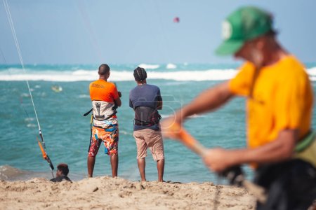 Foto de Gente deportiva activa disfrutando de vacaciones de kitesurf y actividades en un día soleado perfecto en la playa de arena tropical de Cabarete en República Dominicana - Imagen libre de derechos