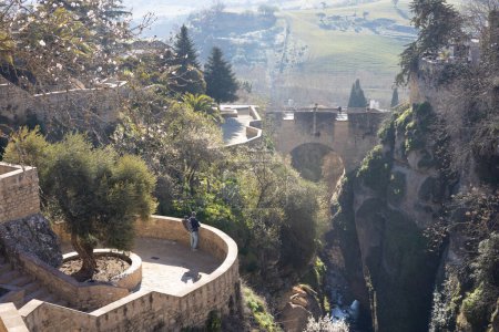 Foto de Vista panorámica de los jardines colgantes de Cuenca sobre la garganta de El Tajo con casas encaladas de Ronda, Andalucía, España - Imagen libre de derechos
