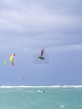 Téléchargez les photos : Kiteboarding. Amusant dans l'océan. Kitesurf Sport Extrême. Kitesurfer saute haut dans les airs en effectuant des voyages pendant la session de kitesurf - en image libre de droit