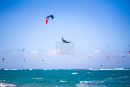 Téléchargez les photos : Kiteboarding. Amusant dans l'océan. Kitesurf Sport Extrême. Kitesurfer saute haut dans les airs en effectuant des voyages pendant la session de kitesurf - en image libre de droit