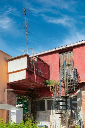 Téléchargez les photos : Cour traditionnelle romaine avec balcon et vieille porte contre un ciel bleu. Rome, Italie. - en image libre de droit
