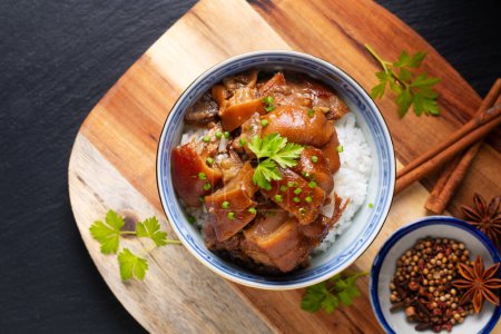 Lebensmittelkonzept Spot focus Hausgemachtes asiatisches 5-Gewürz-Geschmortes Schweinefleisch und Reis auf schwarzem Hintergrund mit Kopierraum