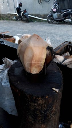 der Prozess des Verbrennens von Kokosnüssen, die dann mit speziellen Gewürzen gemischt werden, um als typisches indonesisches Getränk aus gerösteten Kokosnüssen serviert zu werden