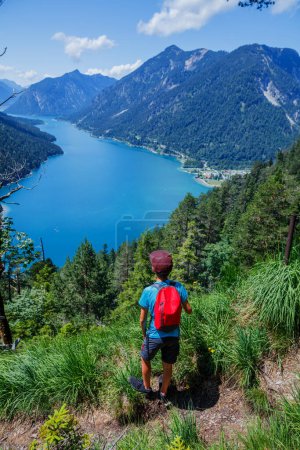 Téléchargez les photos : Hiker in the Alps. Boy backpacker tourist hiking at Lake. Alps, Bavaria, Germany - en image libre de droit