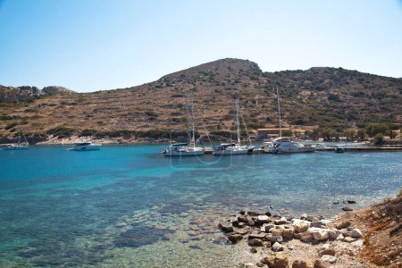 Photo for Yachts and ships from various countries are on vacation in the natural harbor area of the Ancient City of Knidos. Turkey Mugla Datca, June 28 2023 - Royalty Free Image