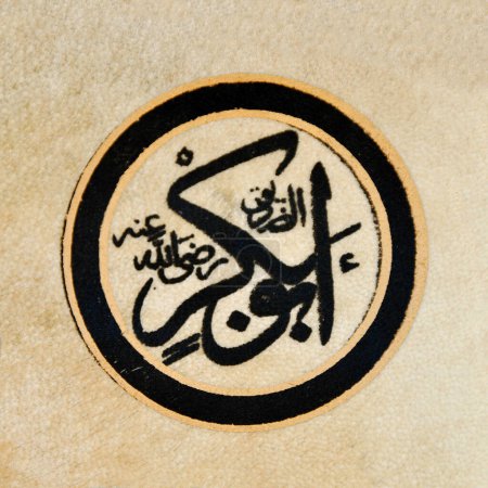 Téléchargez les photos : Caractères de calligraphie islamique sur cuir de peau avec un stylo de calligraphie fait main, nom Abu Bakr art islamique - en image libre de droit