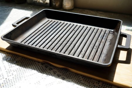 Empty black cast heavy iron grill pan on modern kitchen countertop, modern kitchen equipment