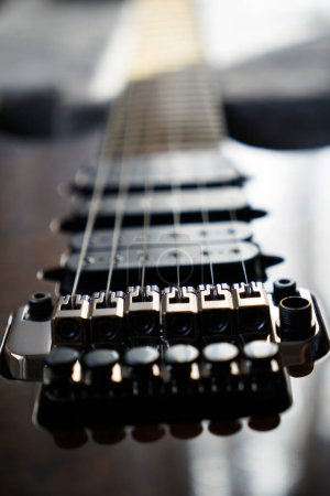 Pont à guitare électrique, cordes et pick-up, détail vue rapprochée du pick-up à guitare en noyer de bois, instrument de musique à cordes