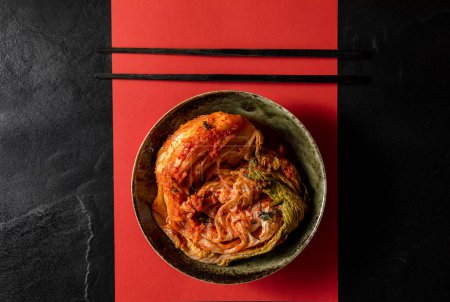 Téléchargez les photos : Kimchi in bowl on red and black - en image libre de droit