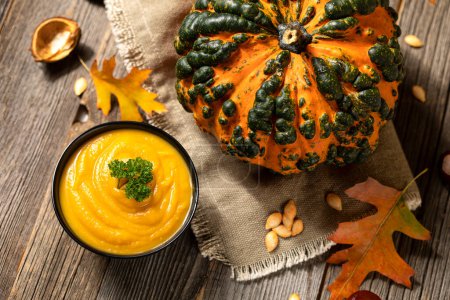 Téléchargez les photos : Pumpkin soup and raw pumpkin in fall on table - en image libre de droit