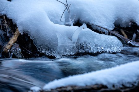 Téléchargez les photos : River flow in snow and icicles in winter - en image libre de droit