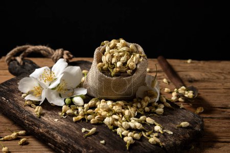 Téléchargez les photos : Fresh and dry jasmine flowers for tea on wood - en image libre de droit