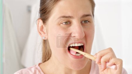 Photo for Portrait of brunette woman brushing her perfect white teeth with toothbrush. - Royalty Free Image
