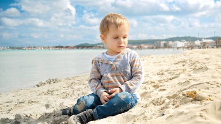 Foto de Pequeño niño de vacaciones en la playa, jugando en la arena. Concepto de turismo, viajes, vacaciones de verano. - Imagen libre de derechos