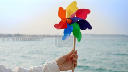 Foto de Mujer joven jugando con un colorido volante giratorio en la playa de arena de mar. Vacaciones de verano, viajes y emociones positivas - Imagen libre de derechos
