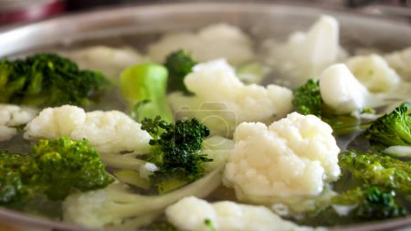 Téléchargez les photos : Macro shot de soupe chaude vaporisatrice avec cuisson du chou-fleur et du brocoli en pot. Concept de saine alimentation, aliments biologiques, végétalien et végétarien. - en image libre de droit
