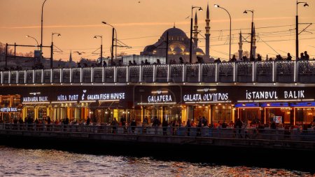 Foto de Famosos restaurantes y pescadores turcos pescando en el puente de Galata al atardecer en Estambul. 15 de marzo de 2023, Turquía, Estambul - Imagen libre de derechos