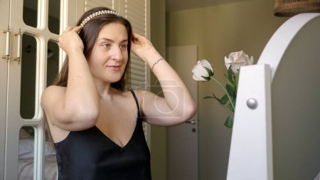 Téléchargez les photos : Belle femme élégante faisant coiffure avec perle cerceau de cheveux. Mode, style féminin et beauté - en image libre de droit