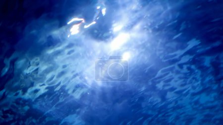 Téléchargez les photos : Rayons de lumière du soleil et des rayons brillants à travers la surface de l'eau dans la piscine ou l'aquarium. Fond ou toile de fond sous-marine abstrait. - en image libre de droit