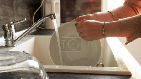 Téléchargez les photos : Gros plan de femme lavant la vaisselle dans l'évier avec une éponge. Travail de femme au foyer, tâches ménagères, tâches ménagères - en image libre de droit