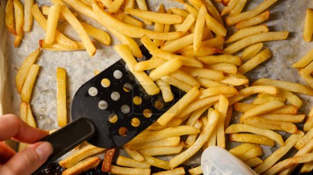 Photo for Closeup of cooking french fries on baking pan. Fast food, healthy nutrition, cooking in oven - Royalty Free Image
