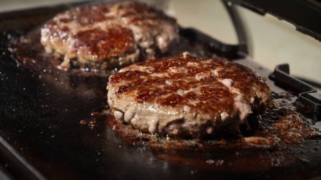 Téléchargez les photos : Faire griller des galettes juteuses pour les hamburgers. Cuisiner à la maison, appareil de cuisine, alimentation saine, ingrédients pour hamburgers - en image libre de droit