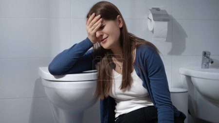 Foto de Mujer molesta y triste llorando en el suelo en el baño en casa. Concepto de depresión, suicidio, estrés, enfermedad mental, soledad y frustración - Imagen libre de derechos