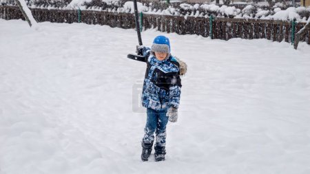 Téléchargez les photos : Petit garçon jouant sur une aire de jeux avec tyrolienne par une journée d'hiver enneigée. Enfants jouant et s'amusant à l'extérieur pendant les vacances d'hiver et week-end. - en image libre de droit