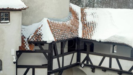 Foto de Nieve soplada desde los tejados rojos del castillo medieval en la ventisca de nieve. - Imagen libre de derechos