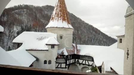 Téléchargez les photos : Toits et tours couverts de neige dans le château médiéval en hiver. - en image libre de droit